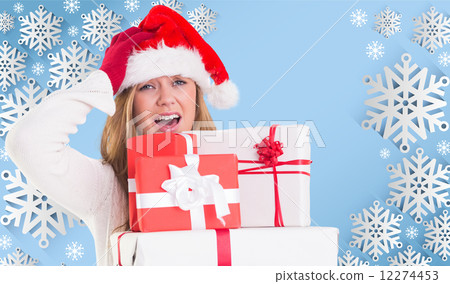 Composite image of festive blonde holding pile of gifts 12274453