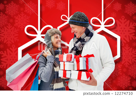 Composite image of festive mature couple holding christmas gifts 12274710