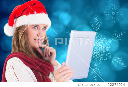 Composite image of festive blonde looking at tablet pc Composite image of festive blonde looking at tablet pc 12274924
