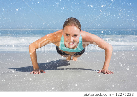 Fit woman in plank position on the beach 12275228