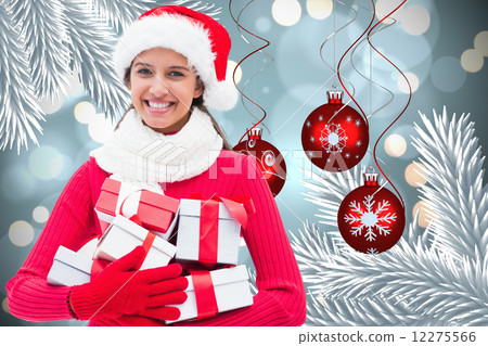 Composite image of festive brunette holding gifts 12275566