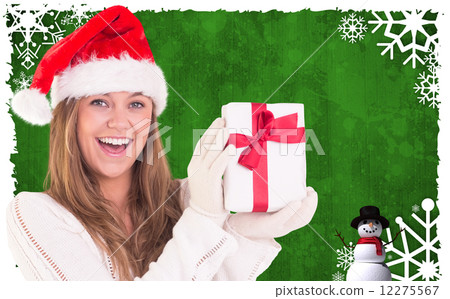Composite image of festive blonde holding a gift 12275567