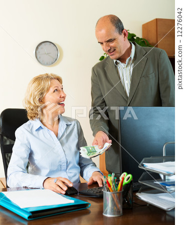 Happy female secretary receiving from boss salary 12276042