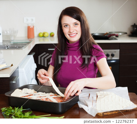 happy woman cooking fish pie with raw salmon 12276237