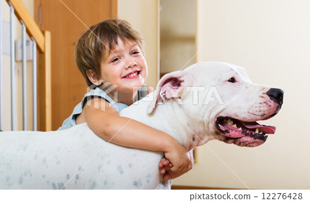 Little girl hugging white dog 12276428