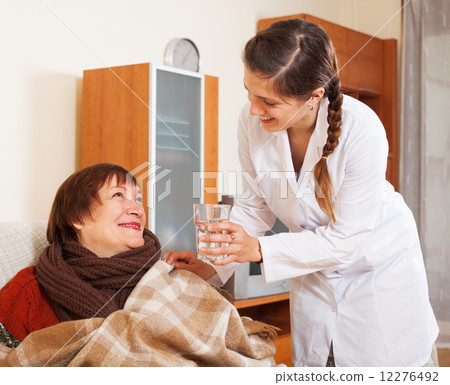 nurse in uniform caring for happy mature woman 12276492