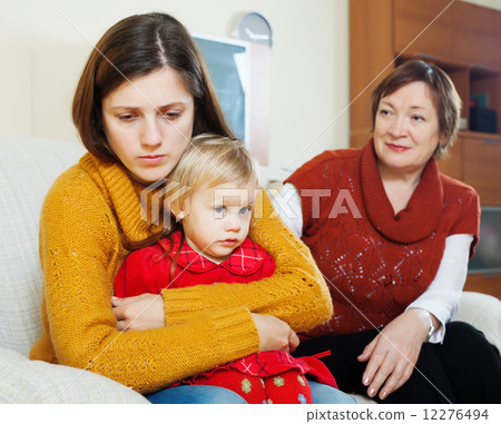 Conflict between sad woman with baby and mature mother 12276494