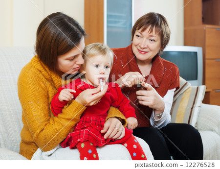 mother with mature grandmother caring for sick baby mother with mature grandmother caring for sick baby 12276528