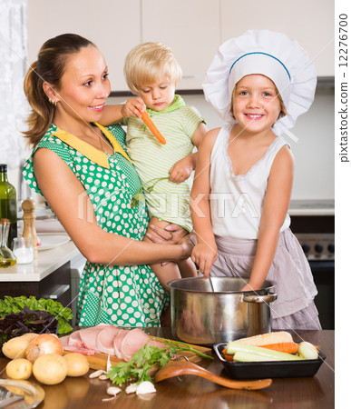 Mother with two daughters cooking 12276700