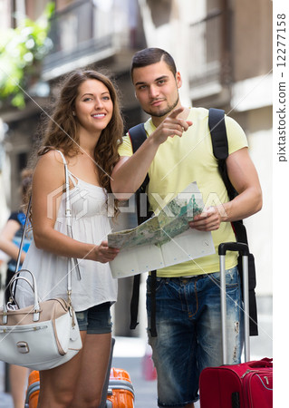 Couple with luggage reading map 12277158
