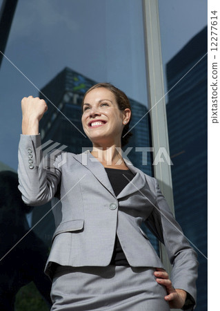 Businesswoman making success hand gesture outdoors 12277614