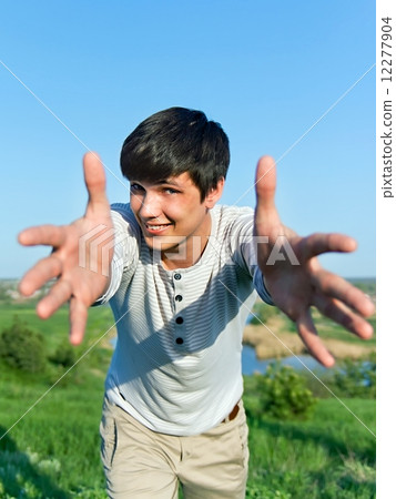 cheerful guy with outstretched arms outdoors 12277904