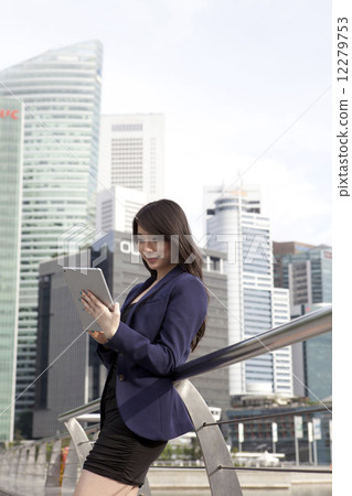 Businesswoman leaning on railing using tablet outdoors 12279753