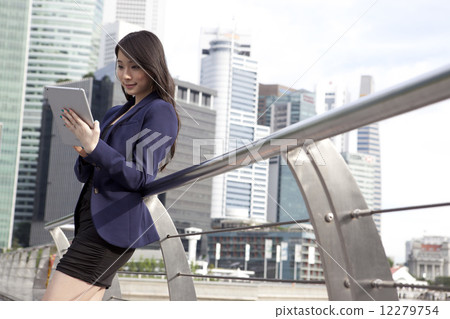 Businesswoman leaning on railing using tablet outdoors 12279754