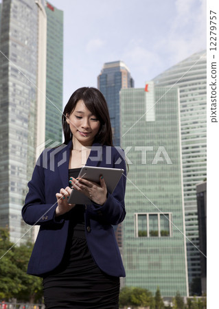 Businesswoman using tablet outdoors 12279757