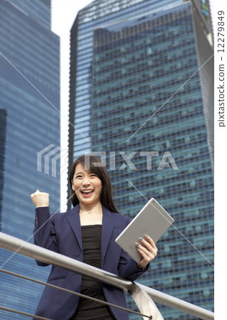 Businesswoman with tablet making success hand gesture outdoors  12279849