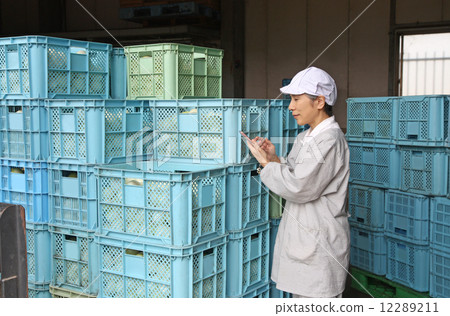 A woman who operates a smartphone in front of a carry with onions 12289211