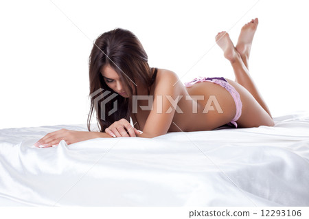 Studio shot of beautiful slim model lying in bed Studio shot of beautiful slim model lying in bed 12293106