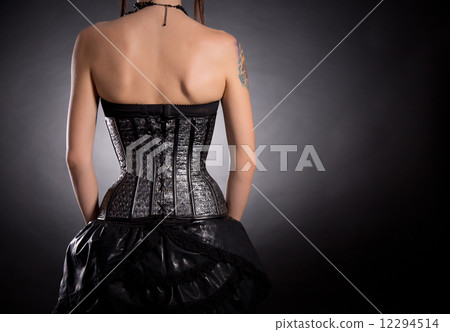 Back view of woman in silver leather corset 12294514