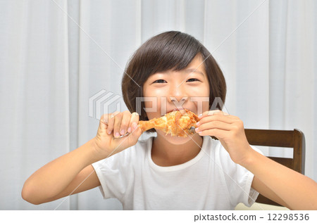 A girl who eats fried chicken deliciously A girl who eats fried chicken deliciously 12298536