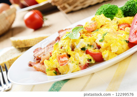 Omelette with vegetables and fried bacon 12299576