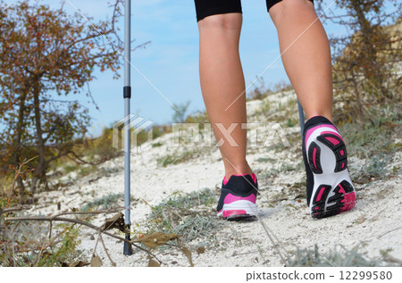 Female feet and trekking stick 12299580