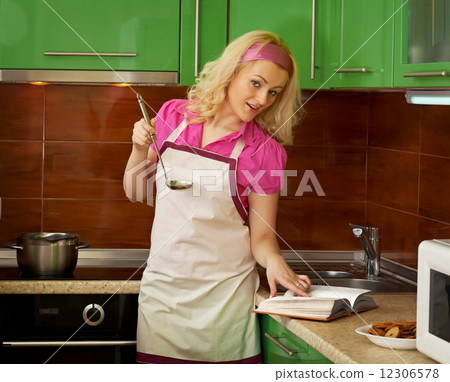 Young housewife preparing with cook book 12306578