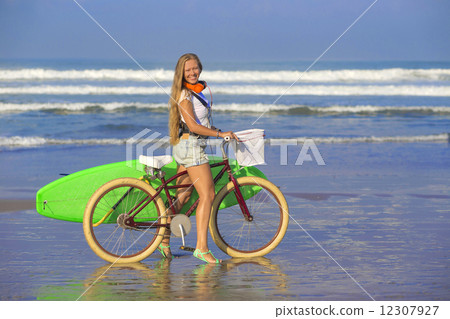 Young girl with surfboard and bicycle 12307927