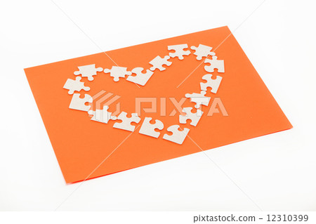Puzzles in the shape of a heart on an orange background. Puzzles in the shape of a heart on an orange background. 12310399