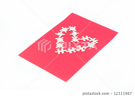 Puzzles in the shape of a heart on a red background. 12311987
