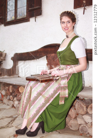 Young Bavarian girl playing the zither on a bank Young Bavarian girl playing the zither on a bank 12312779