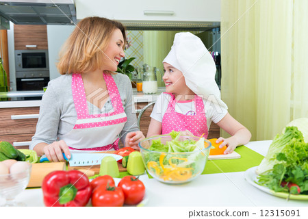 Happy mother and daughter cooking a salad. 12315091
