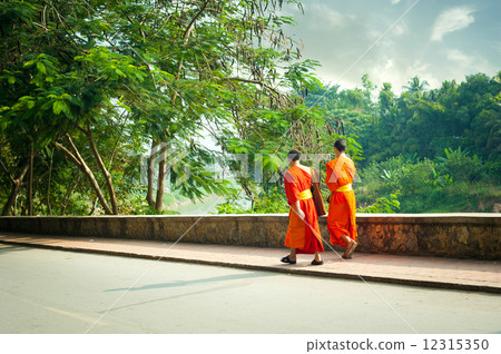 Young buddhist monks at city street. Luang Prabang, Laos Young buddhist monks at city street. Luang Prabang, Laos 12315350