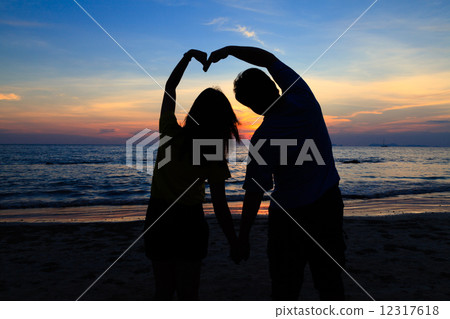 Asian boy and girl with heart shape on the sunset beach 12317618