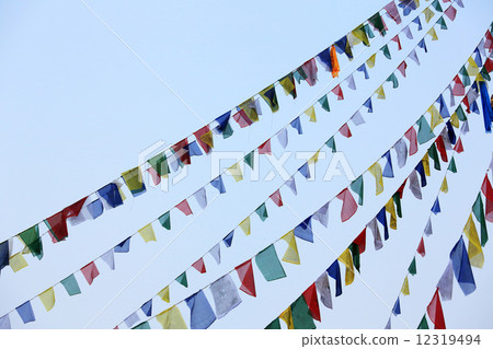 Buddhist tibetan prayer flags waving in the wind against blue sk Buddhist tibetan prayer flags waving in the wind against blue sk 12319494