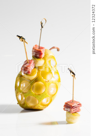 Appetizer. Creative cuisine. Prosciutto with pear on a white background. 12324372