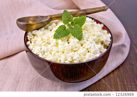 Curd in wooden bowl with spoon and mint on napkin 12326989