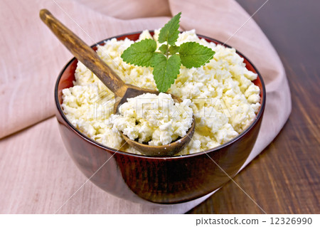 Curd in wooden bowl with spoon and mint on board 12326990