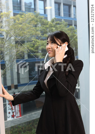 Asian business woman talking on the phone Asian business woman talking on the phone 12327054