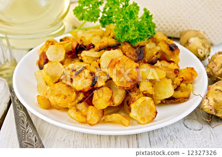 Jerusalem artichokes fried in plate on light board 12327326