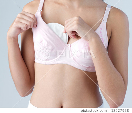 Woman putting absorbent pad to her breast for protect milk dripping 12327928