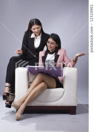 Two girls sharing happy moment in office Two girls sharing happy moment in office 12329901