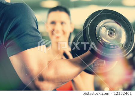 Personal Trainer in gym and dumbbell training