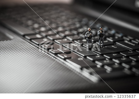 Miniature swat squad protecting laptop computer. Technology concept 12335637