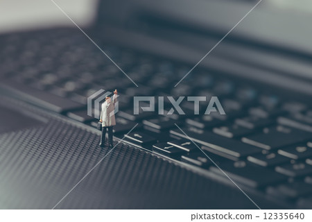 Miniature businessman waving on top of the laptop. Business concept 12335640