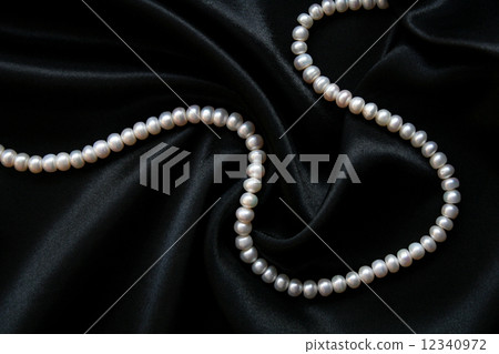 White pearls on the black silk 12340972