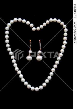 Necklace of white pearls and golden earrings with diamonds on t 12340981