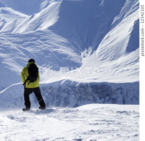 Snowboarder on top of off-piste slope at windy day 12342105