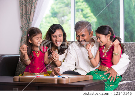 Indian family playing carrom game at home. Parents and children 12343146