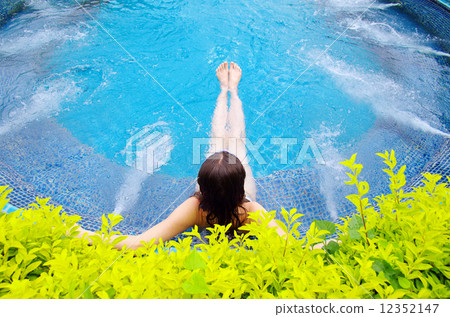 woman sitting in swimming pool woman sitting in swimming pool 12352147